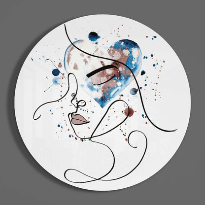 Circular glass wall art featuring minimalist line-drawn profile with blue and brown watercolor splashes on white background.
