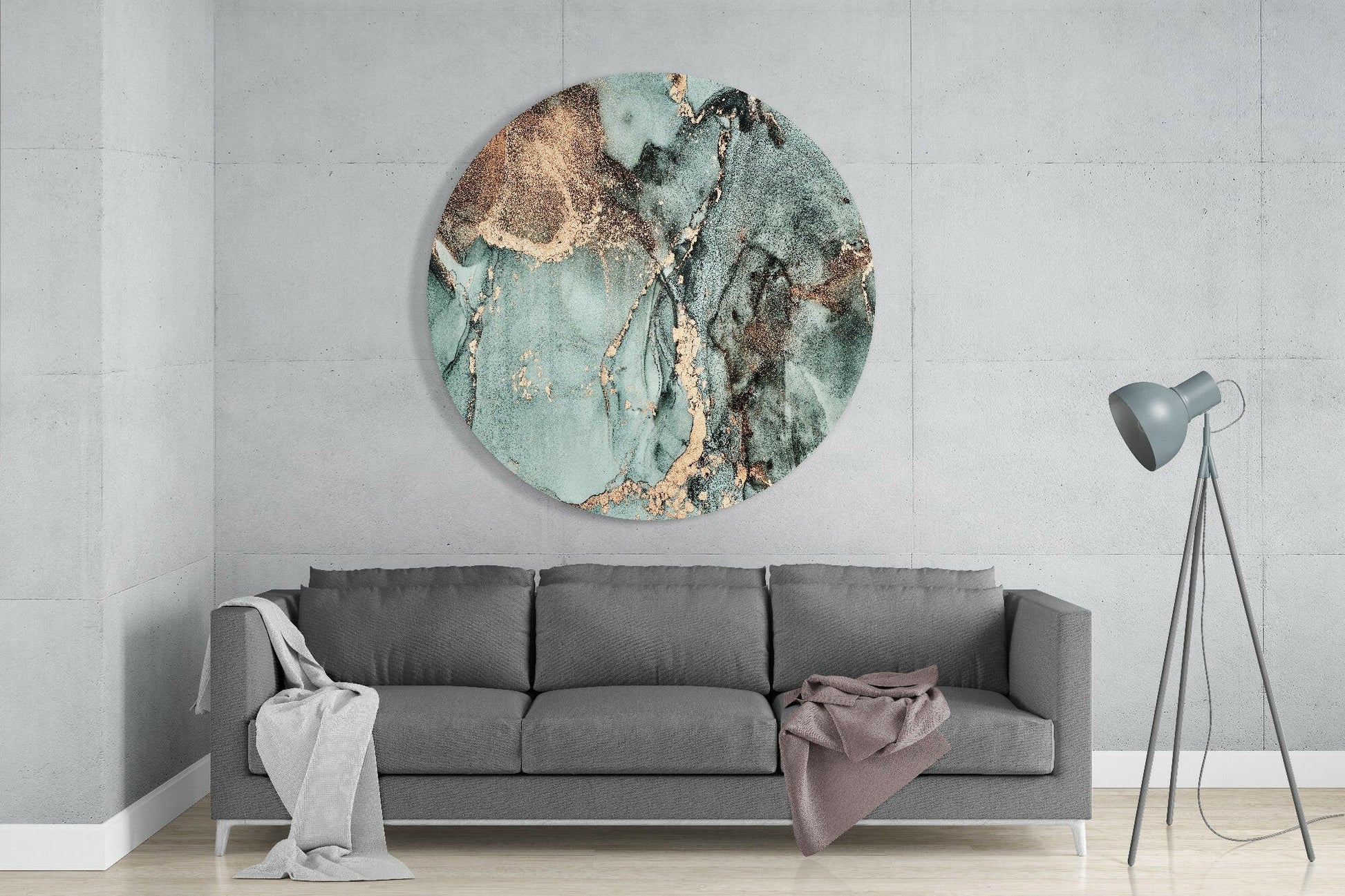 Round turquoise and brown marble glass wall art hanging above gray sofa in minimalist living room interior.