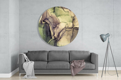 Round glass wall art with green and cream watercolor marble pattern displayed above gray sofa in modern living room interior.