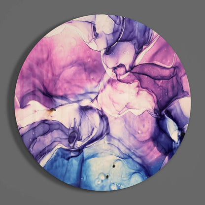 Circular glass wall art with swirled pink, purple, blue, and cream marbled pattern against gray background.