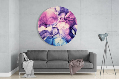 Round pink and purple marble glass wall art displayed above gray sofa in minimalist living room interior.
