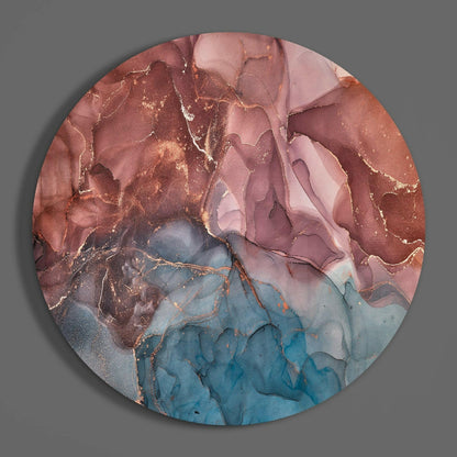 Circular glass wall art with flowing marbled patterns in terracotta, pink, and blue tones with gold accents, viewed from front.