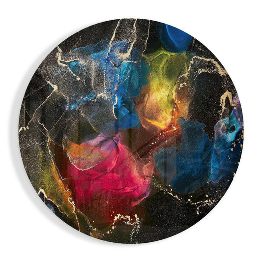 Round black glass wall art with vibrant multicolored ink bloom design featuring blue, pink, yellow, and gold swirling patterns with glittery accents.