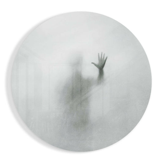 Frosted glass circular panel displaying a blurred silhouette of a person with raised arm against white background.