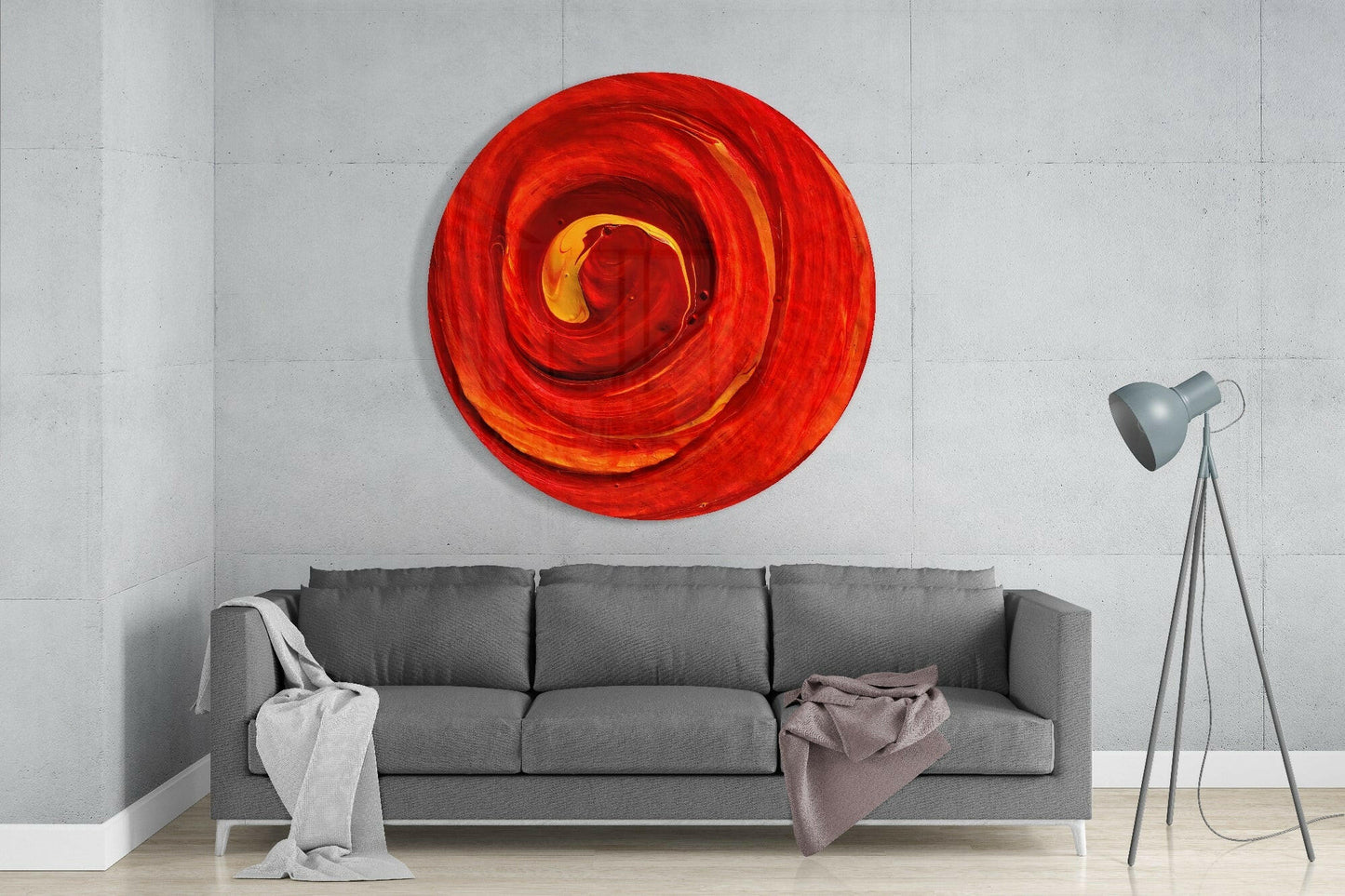 Red and orange swirled glass wall art circle mounted above gray sofa in modern living room interior.