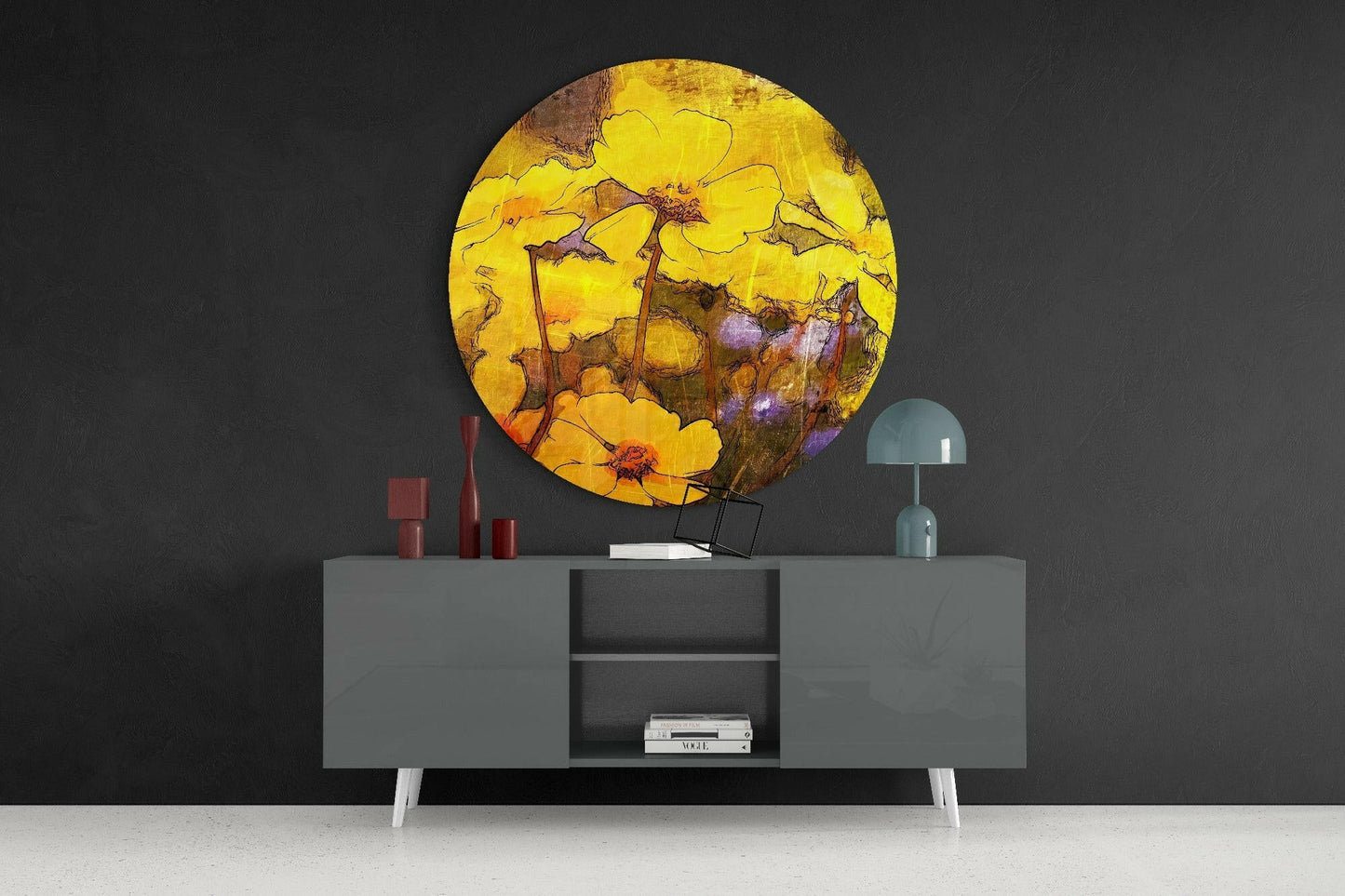 Round yellow glass wall art with brown botanical details displayed above a gray modern credenza with white legs and decorative accessories.
