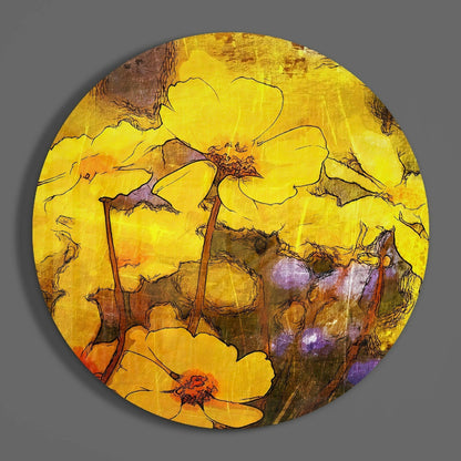 Circular glass wall art featuring yellow flowers with brown stems and green leaves on textured yellow and brown background, displayed flat against gray surface.