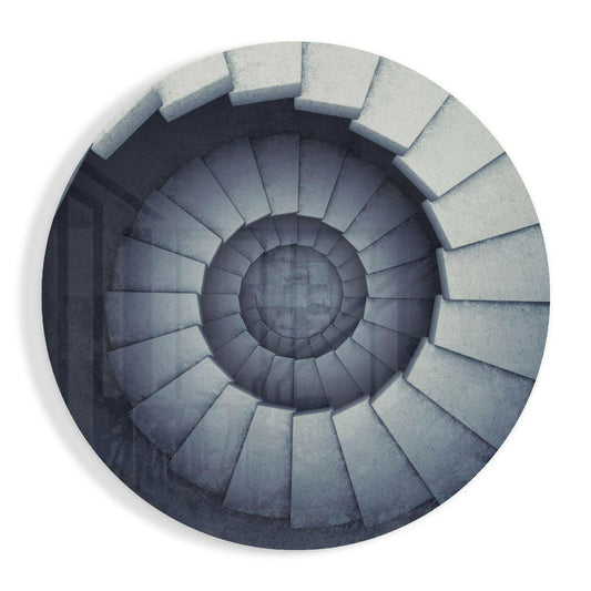 Overhead view of a spiral staircase with concrete steps descending into darkness, rendered in grayscale tones.
