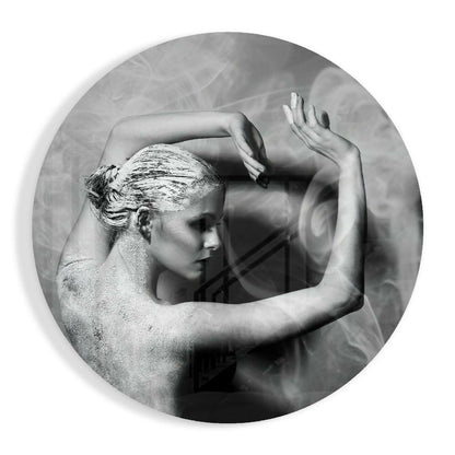Black and white circular glass art featuring a sculptural profile of a woman with her arms raised, textured background visible through translucent center.