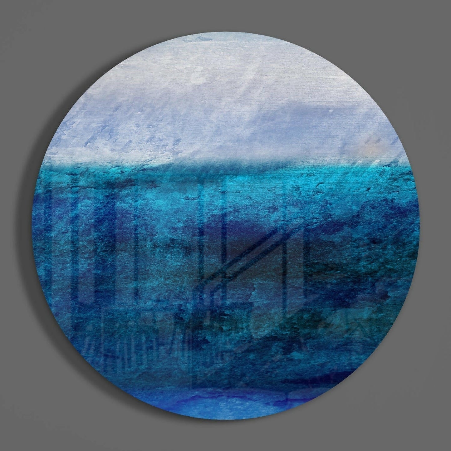 Circular glass wall art displaying layered ocean and sky gradient, transitioning from white clouds at top through turquoise and deep blue water tones below.