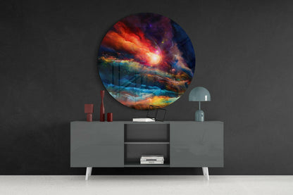 Circular glass wall art displaying vibrant red, orange, and blue cosmic imagery mounted above a gray sideboard with decorative items.