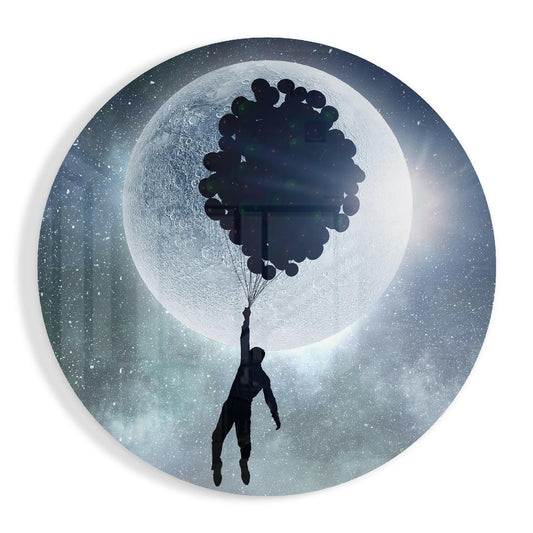 Silhouetted figure suspended by black balloons against a luminous full moon in a starry night sky on circular glass art.