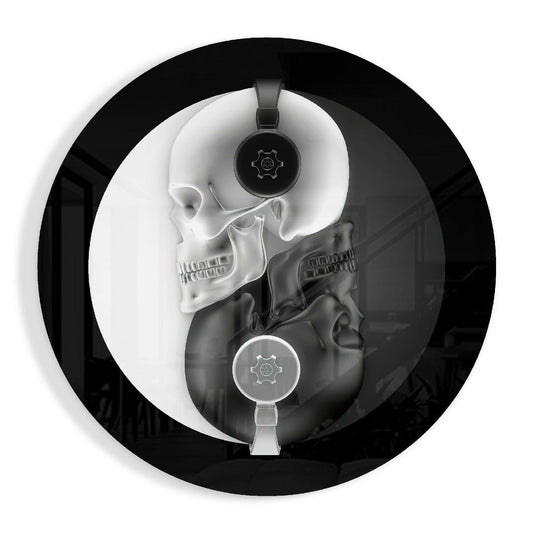 Top-down view of circular glass wall art featuring two skulls in a yin-yang composition with headphones and gear symbols in monochrome.