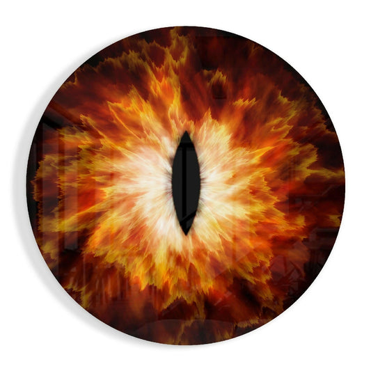 Circular glass wall art featuring a stylized eye with vertical black pupil surrounded by radiating orange, yellow, and red flame-like patterns.