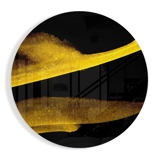 Circular black glass wall art with diagonal gold and bronze textured bands crossing through center, shot straight-on against white background.