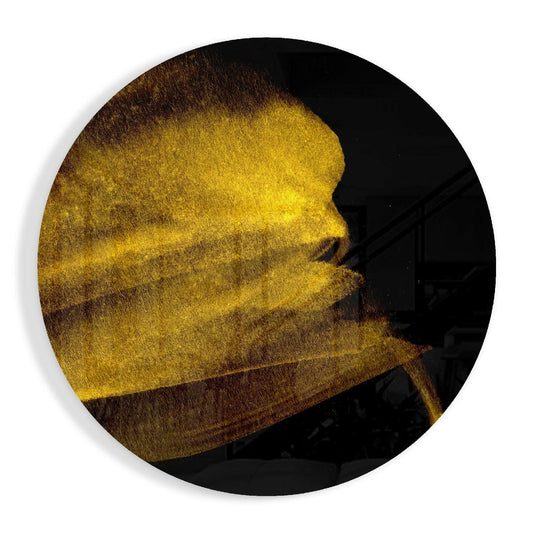 Circular black glass wall art with golden yellow brushstroke design sweeping across surface in profile view.