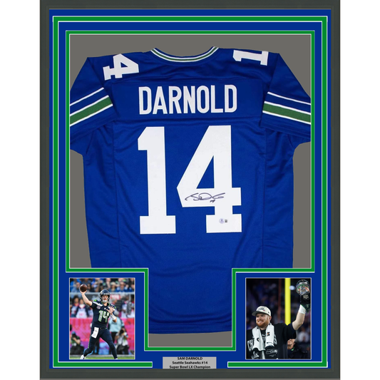 Framed blue Seattle Seahawks #14 jersey signed by Sam Darnold, displayed with two accompanying photos and nameplate in multi-layered green and blue border.