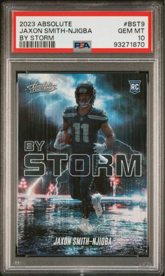 PSA-graded trading card in clear case showing football player Jaxon Smith-Njigba in dark uniform with "By Storm" text and lightning effects on dark background.