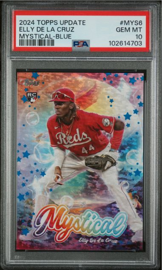 PSA-graded baseball card in clear holder showing Elly De La Cruz in red Reds uniform against colorful mystical blue background with stars.
