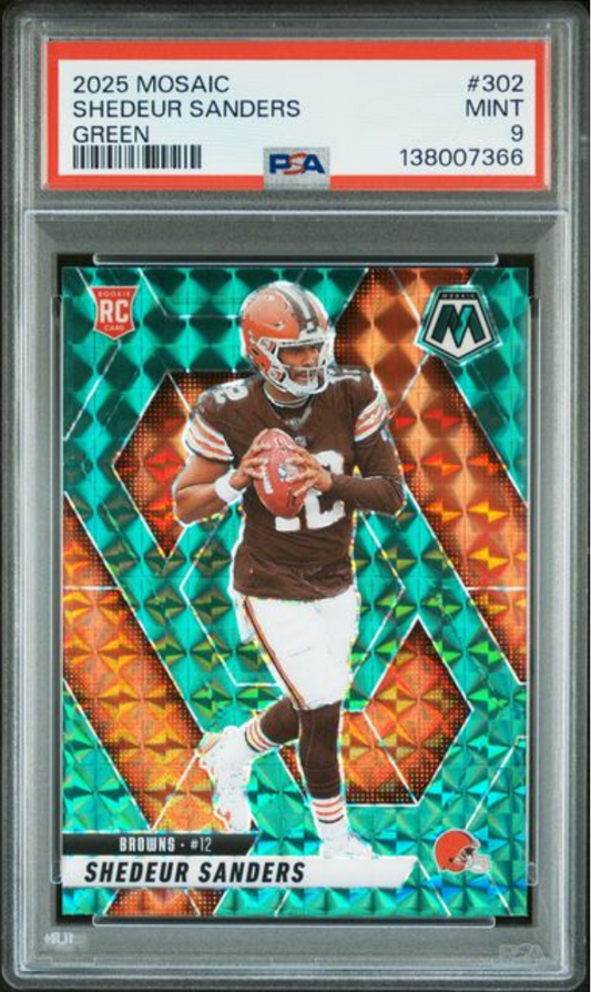 PSA graded rookie card in clear plastic holder showing Shedeur Sanders in brown Cleveland Browns uniform catching football against green and orange mosaic background.
