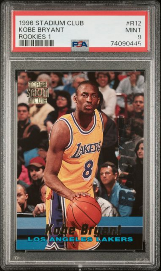 Front of graded 1996 Stadium Club Kobe Bryant rookie card in clear PSA case showing Lakers player in yellow jersey holding basketball.
