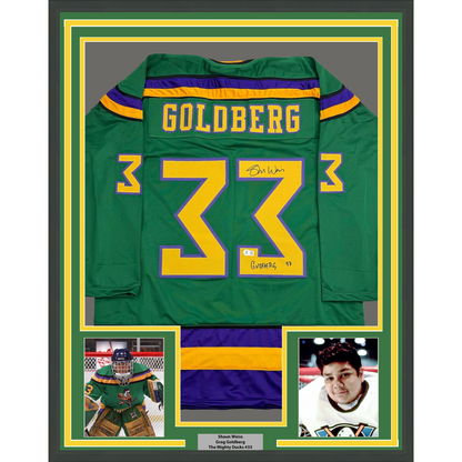 Framed green Mighty Ducks hockey jersey number 33 with "Goldberg" nameplate, signed, displayed with two player photos below.