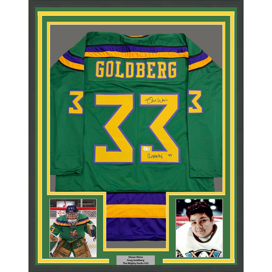 Framed green Mighty Ducks hockey jersey number 33 with "Goldberg" nameplate, signed, displayed with two player photos below.