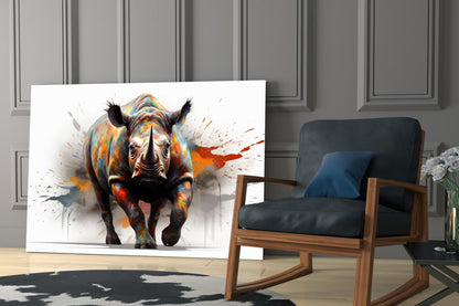 Colorful abstract rhino glass wall art displayed on floor leaning against wall beside mid-century modern wooden chair.