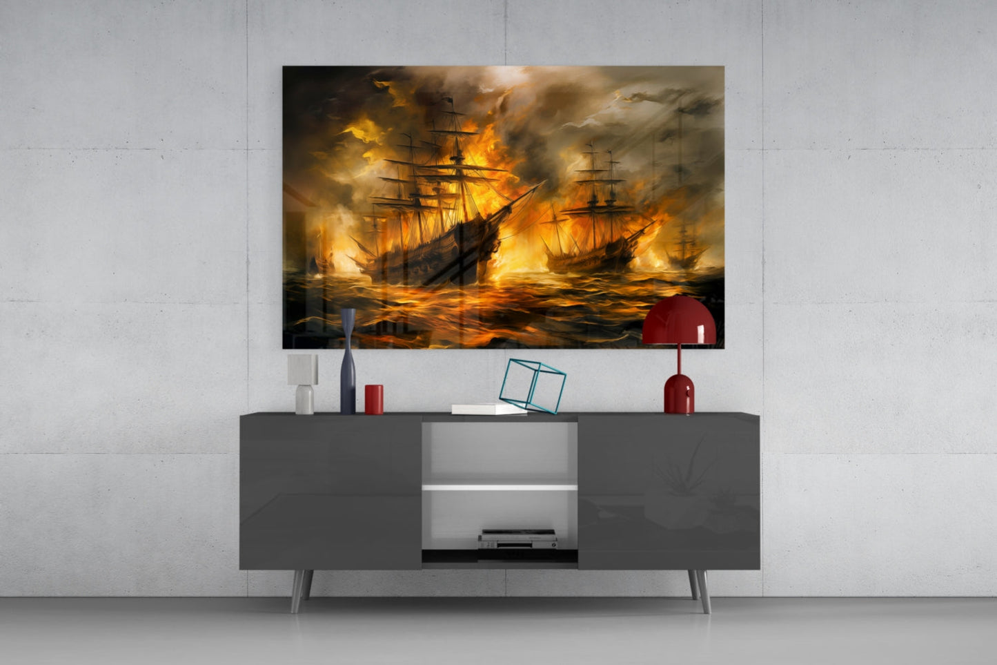 Navy in Flames glass wall art mounted above gray media console, depicting burning sailing ships in golden flames against stormy sky.