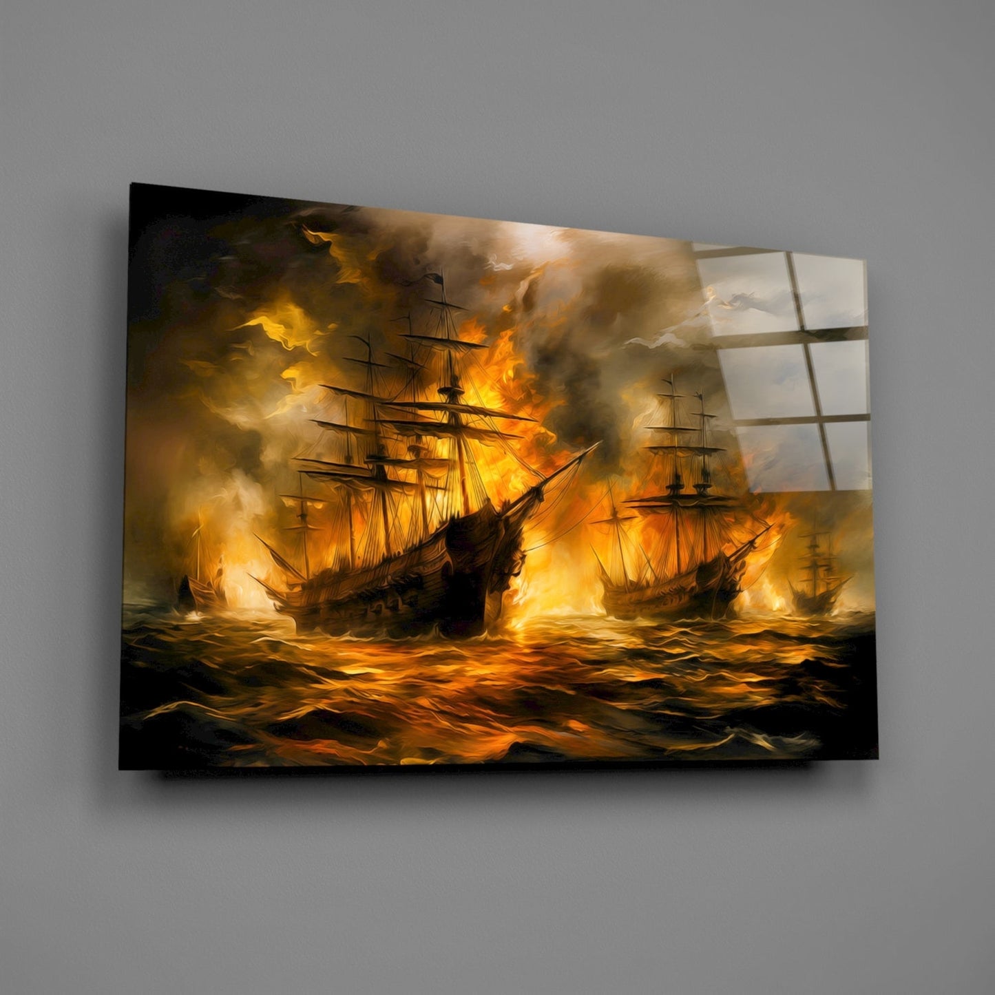 Angled view of glass wall art depicting three burning sailing ships on turbulent golden-orange waters against dark smoky sky.