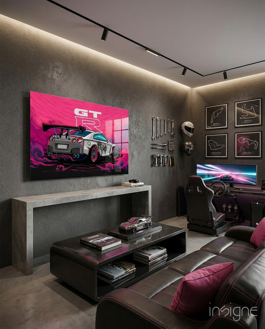 Pink and white Nissan GT-R sports car artwork displayed on gray wall above console desk in gaming room interior.