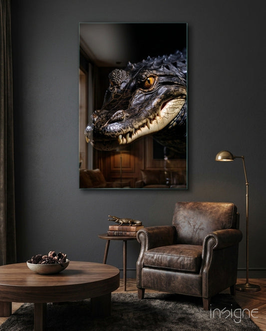 A framed glass art print of a crocodile's head with amber eye displayed on a dark gray wall above a leather armchair in a styled interior room.