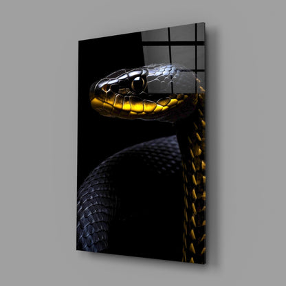 Angled display of black and yellow snake head glass wall art mounted on gray wall with window reflection.