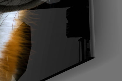Close-up angled view of golden-hued fox glass art with black silhouette shadow cast on white wall beside staircase.