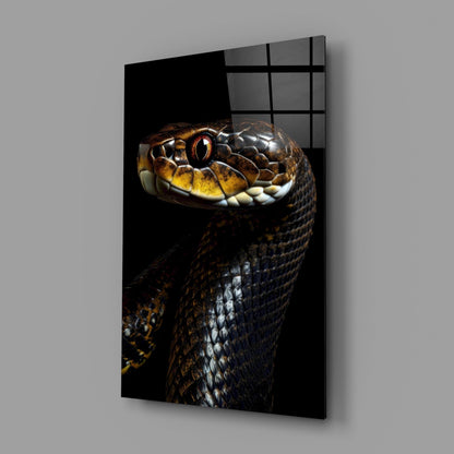 Black framed glass wall art panel displaying close-up portrait of golden-eyed black snake against dark background.
