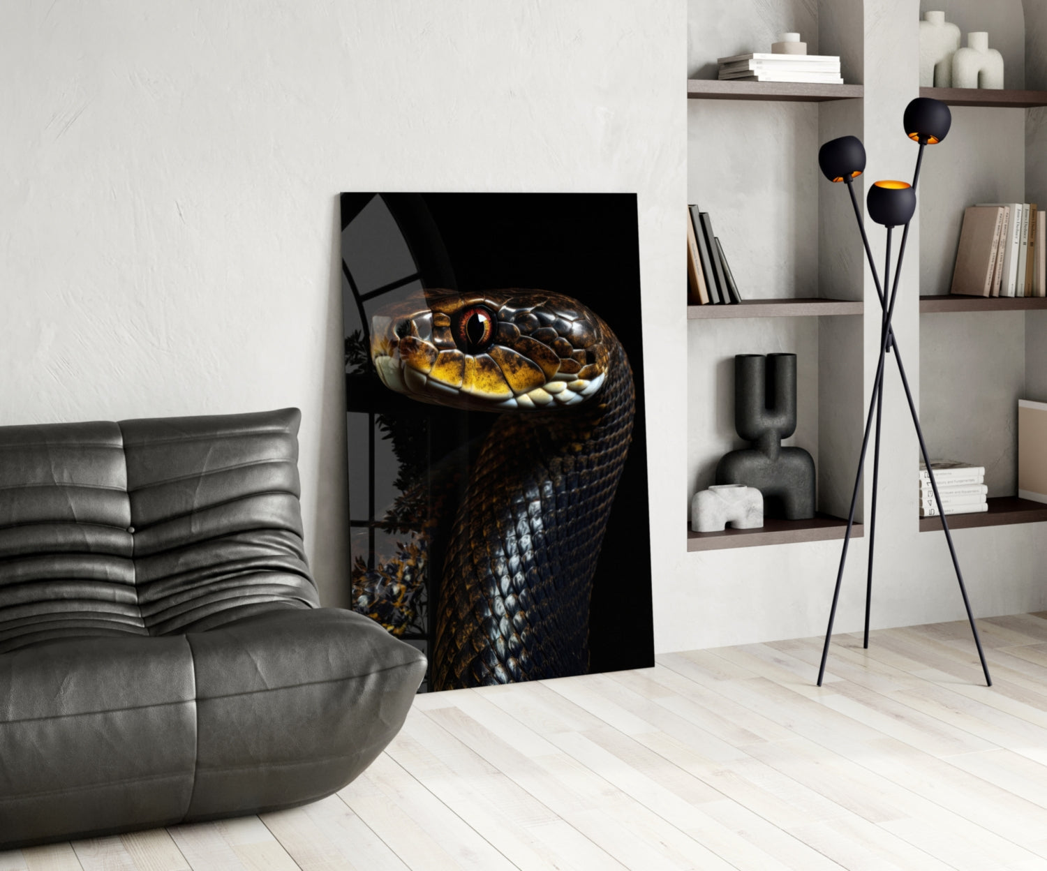 Modern living room displaying golden-eyed black snake glass wall art leaning against white wall beside gray leather sofa.