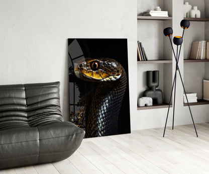 Modern living room displaying golden-eyed black snake glass wall art leaning against white wall beside gray leather sofa.