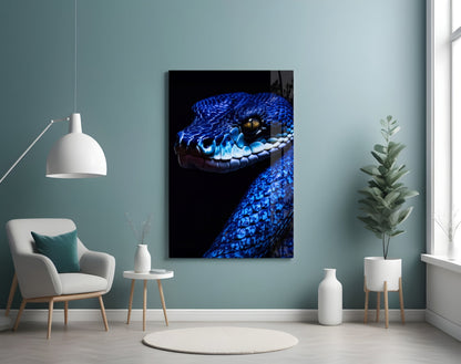 Blue viper glass wall art hanging in a modern living room with teal walls, white chair, and potted plants.