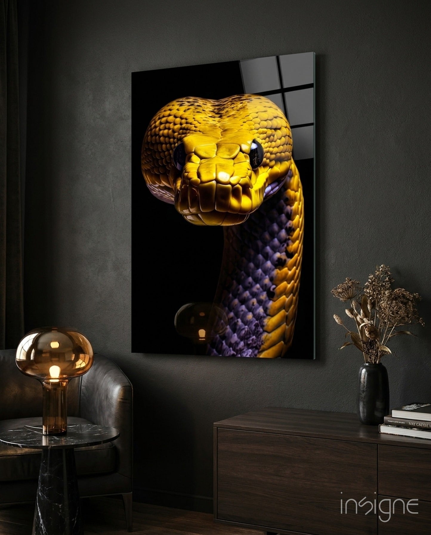 Golden and purple snake glass wall art mounted on dark wall above wooden dresser with lamp and dried flowers.