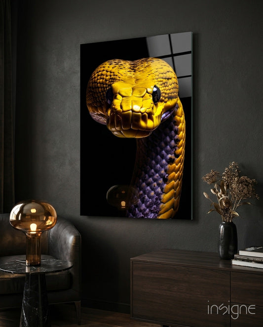 Golden and purple snake glass wall art mounted on dark wall above wooden dresser with lamp and dried flowers.