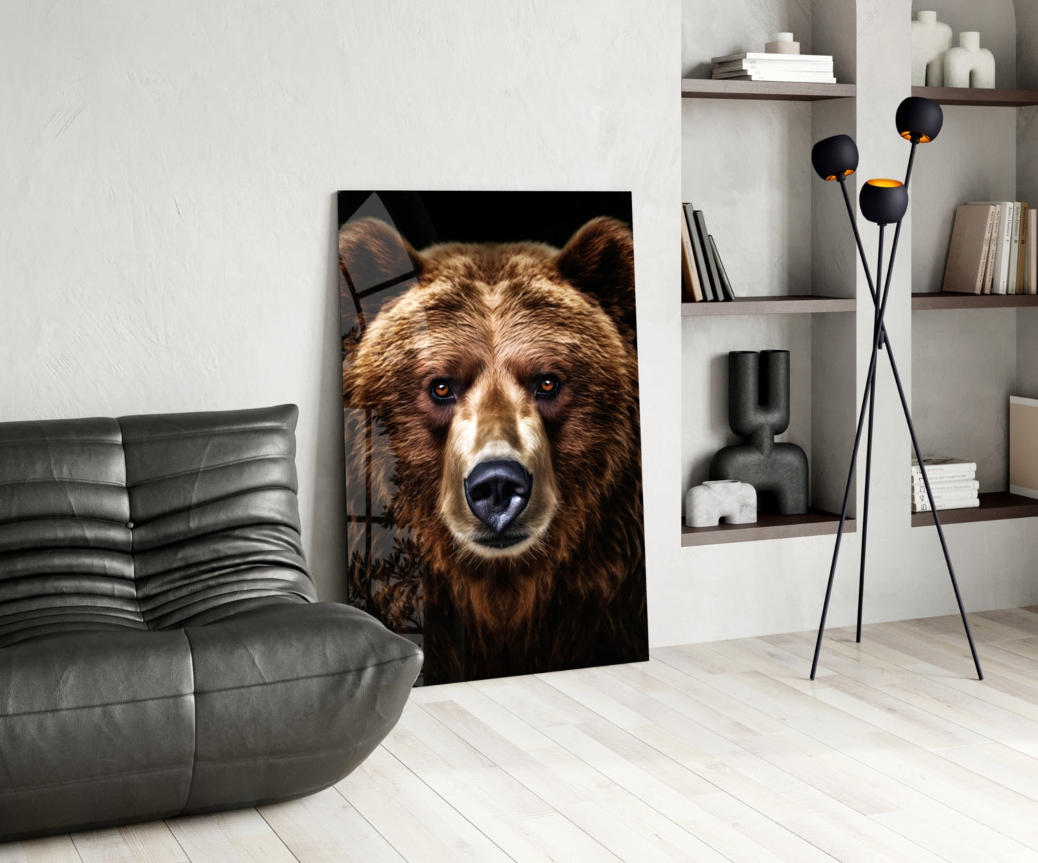 Bear glass wall art featuring a brown bear's face with blue eyes displayed in a modern living room beside a gray chair and shelving unit.