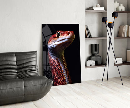 Glass wall art featuring a red and yellow serpent's head in profile against black background, displayed in modern living room setting.