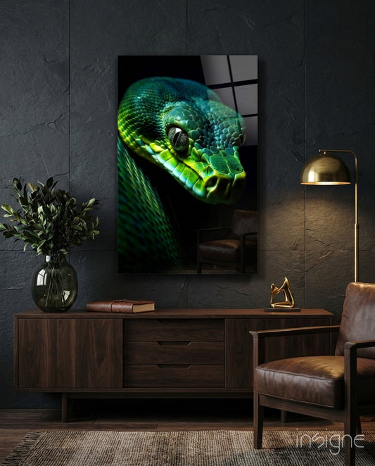 Emerald green viper glass wall art displayed above a wooden sideboard in a dark modern interior with leather chair and brass lamp.