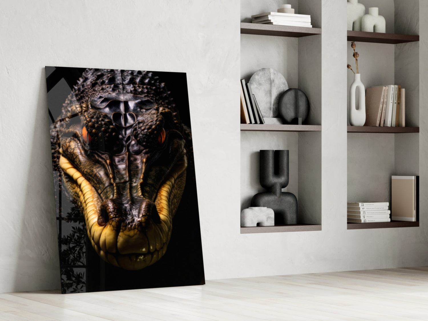Glass wall art leaning against white wall displays close-up crocodile head with golden yellow scales against dark background, displayed in minimalist interior with wooden shelves and decorative objects.