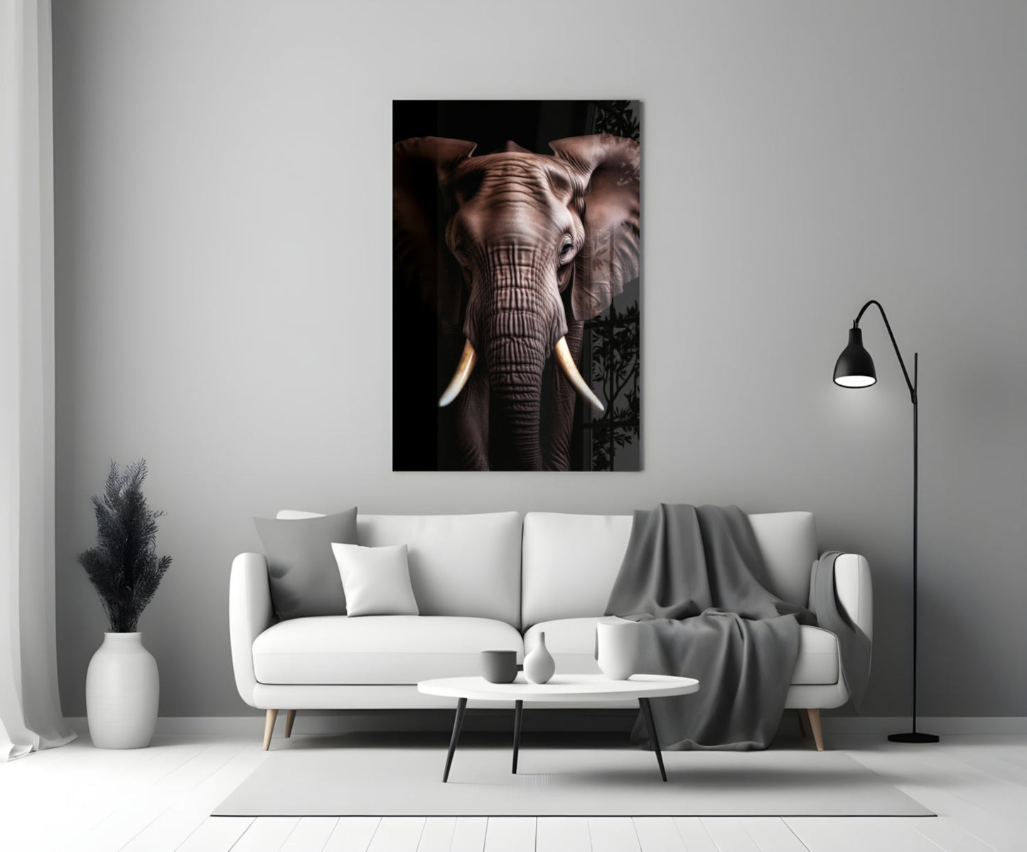 Elephant glass wall art displaying a frontal close-up of an elephant's face with ivory tusks against a black background, hung above a white sofa in a modern living room.