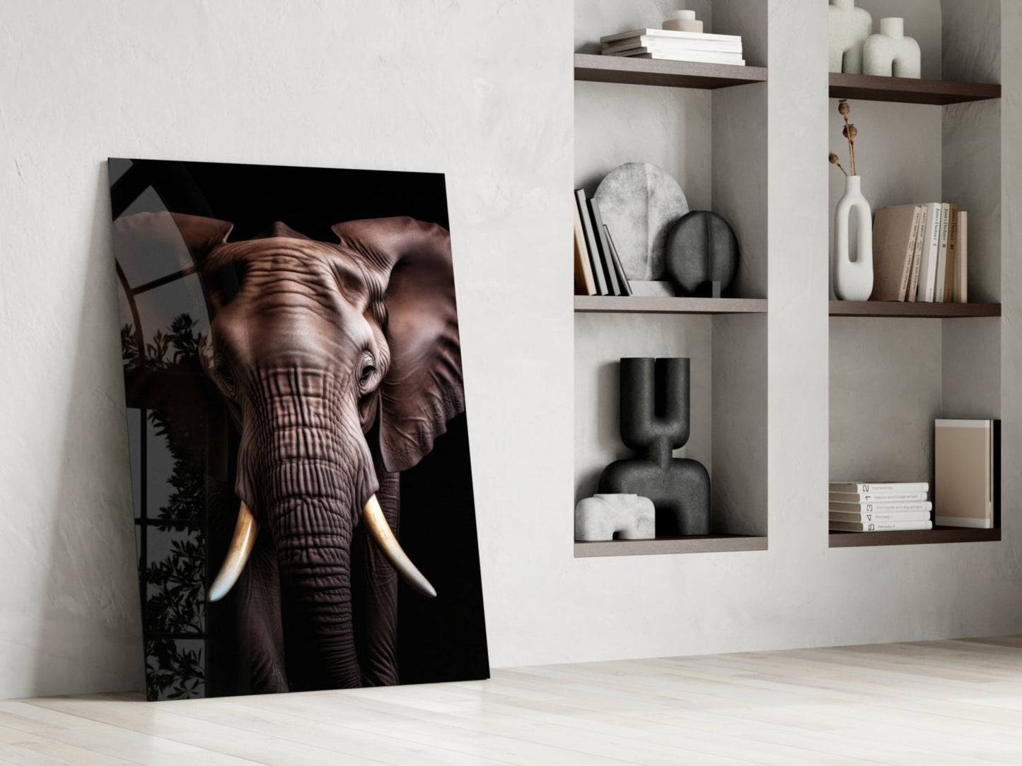 Glass wall art depicting a detailed elephant head with tusks leaning against white wall beside built-in shelving with decorative objects and books.