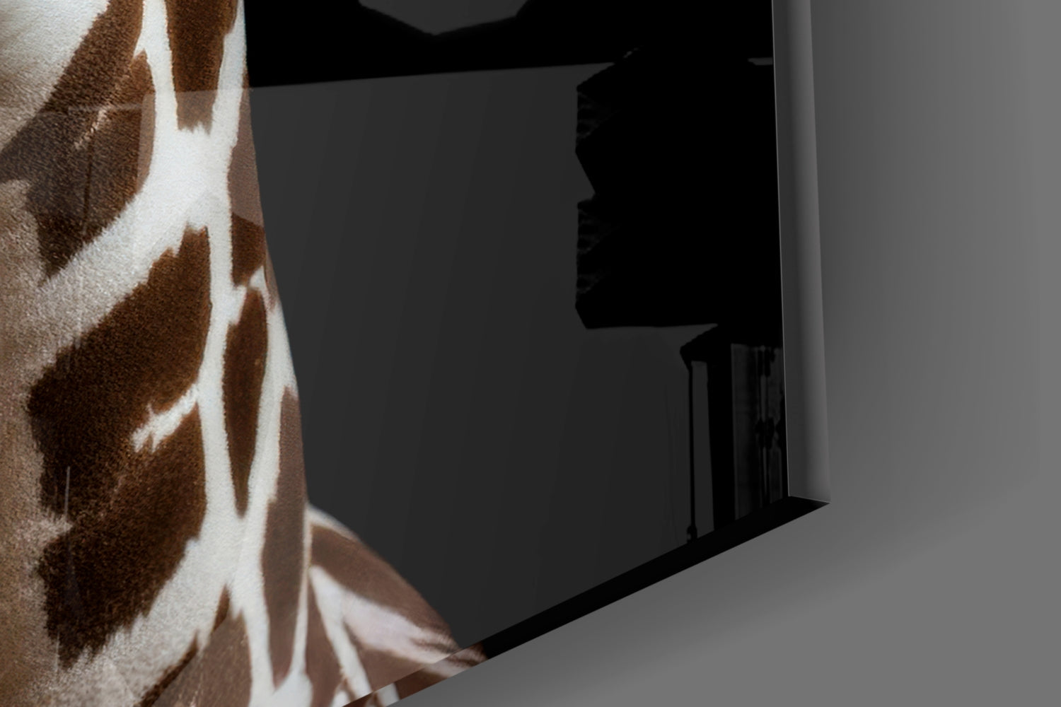 Close-up detail of giraffe glass art showing brown and white spotted pattern with dark interior room reflection visible through glass.