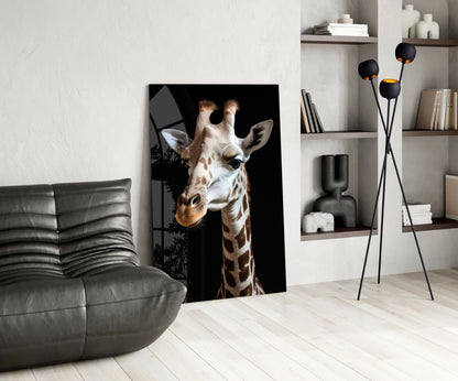 Giraffe portrait glass wall art with tan and white markings displayed in modern living room beside gray sofa and shelving.