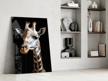 Giraffe portrait glass art leaning against white wall beside shelving unit displaying books and decorative objects.