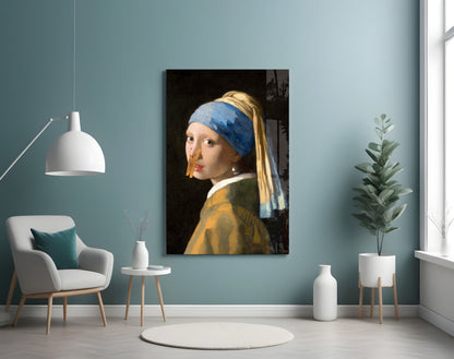 Glass wall art of a girl with a blue headwrap and golden earring displayed in a modern interior with teal walls and white furnishings.